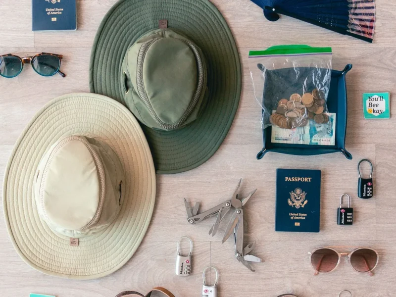 Objetos de viaje, sombreros y pasaportes cerrados distribuidos sobre una superficie