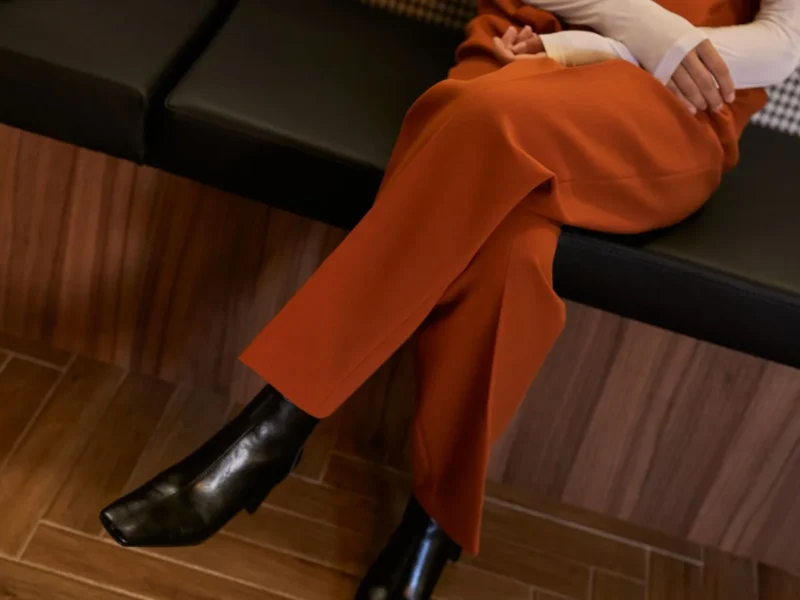 Pantalones anaranjados con botines negros, vistos de cerca