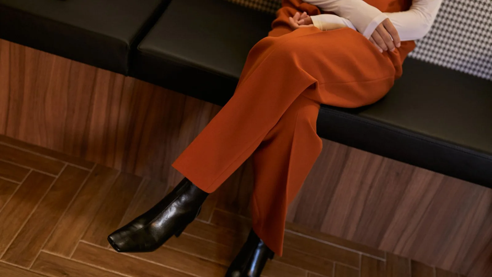 Pantalones anaranjados con botines negros, vistos de cerca