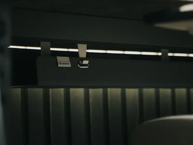 Detalle de una guía bajo el escritorio con cables sujetos y ordenados