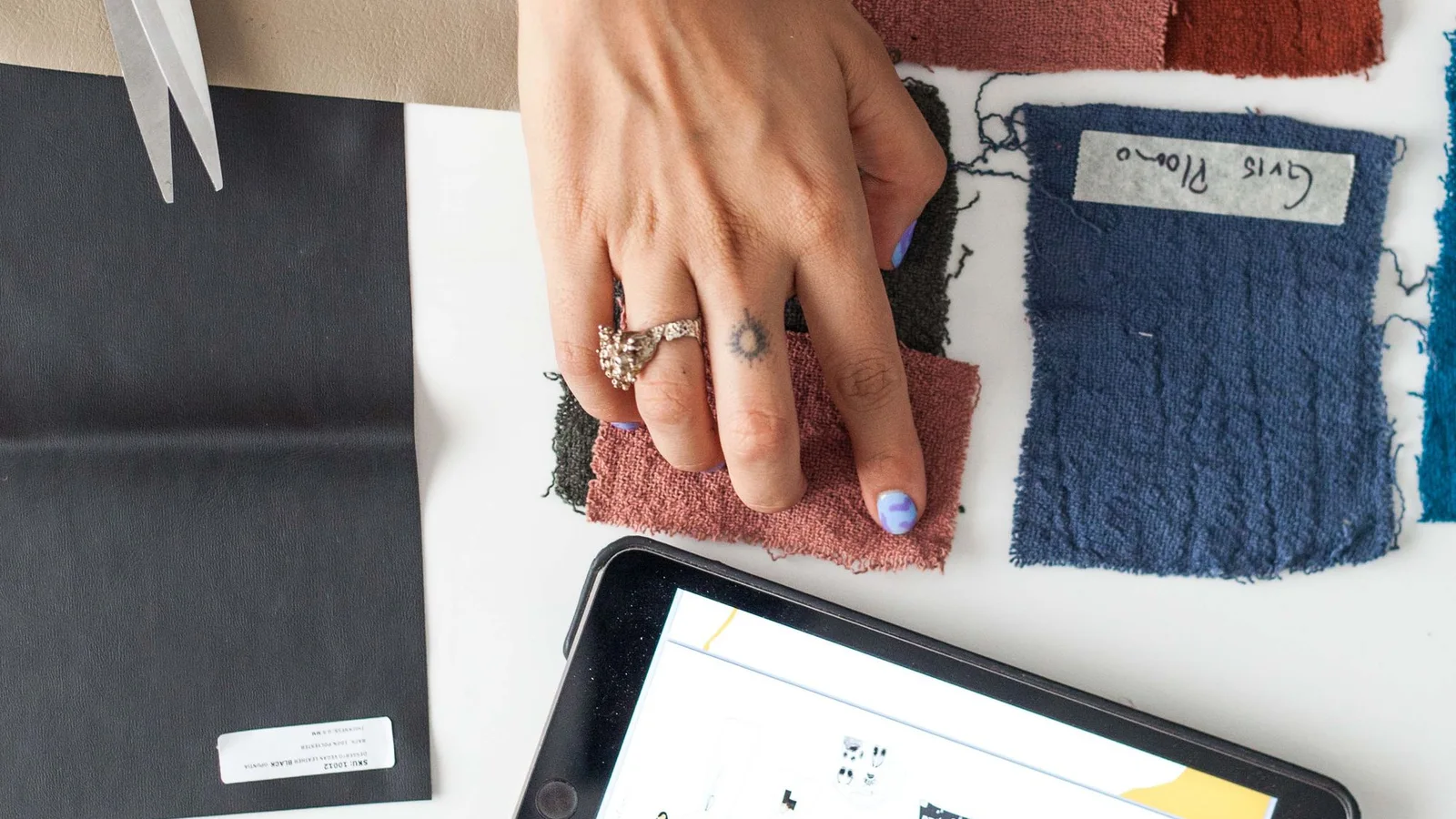Muestras de tejidos y herramientas de diseño sobre una mesa de trabajo
