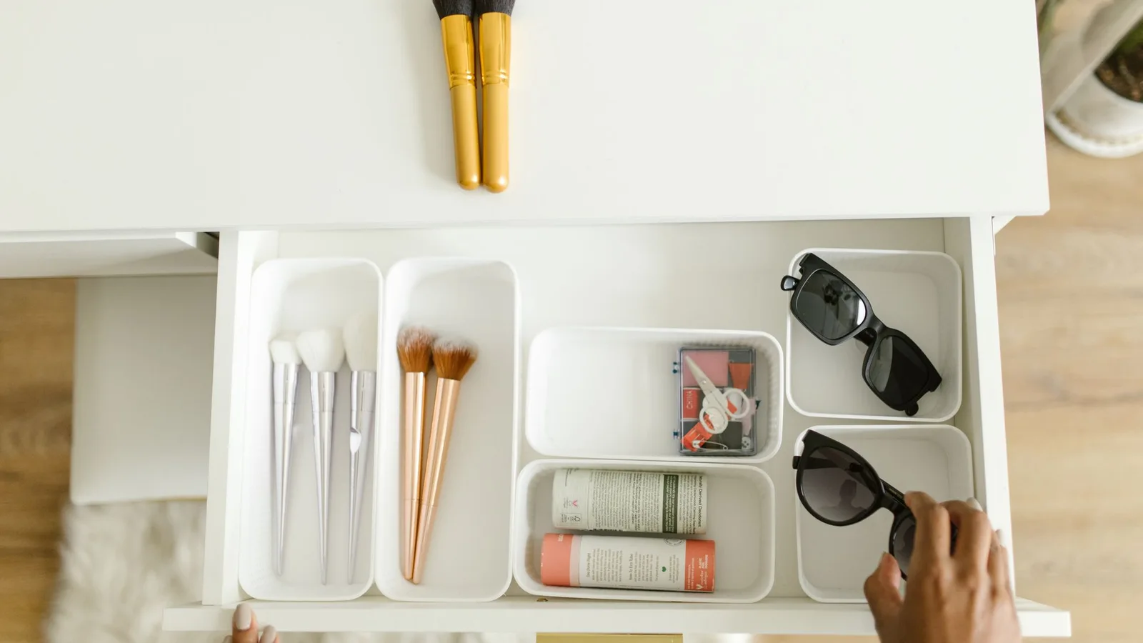 Cajón blanco con compartimentos para brochas, cosméticos y pequeños accesorios.