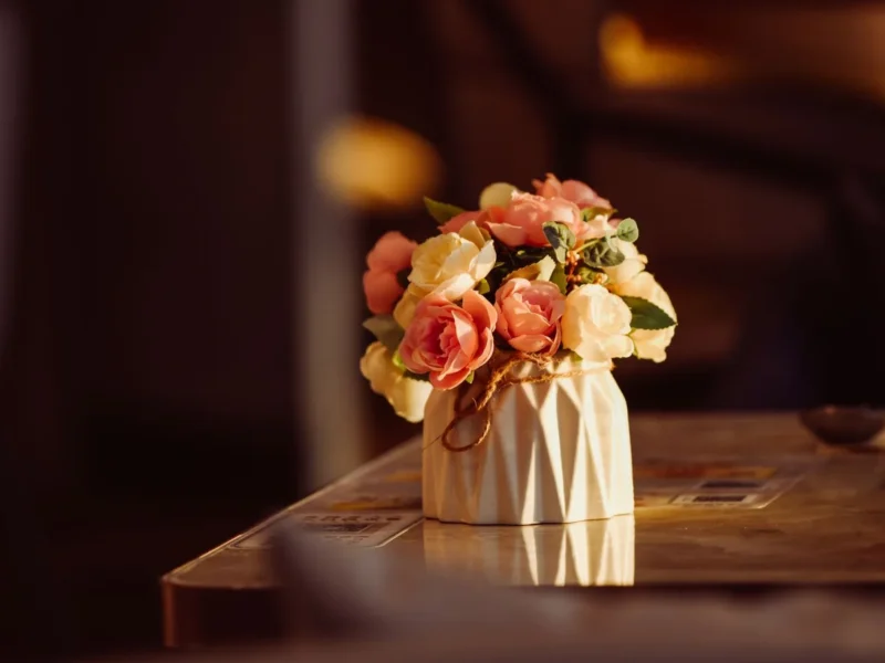 Ramo pequeño de flores rosadas y anaranjadas en un jarrón sobre una mesa
