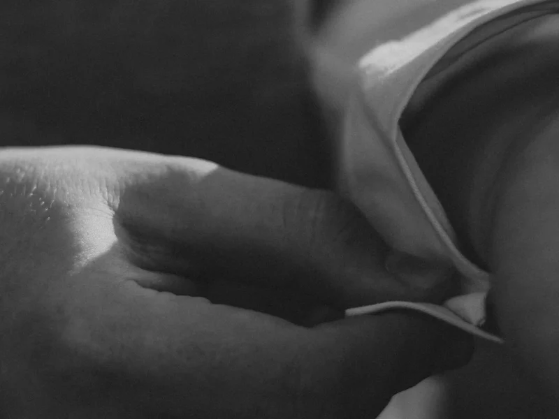 Detalle en blanco y negro de una mano ajustando un puño