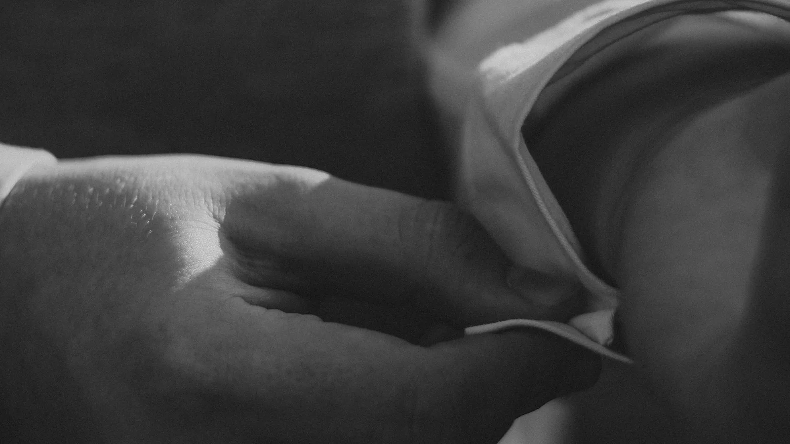 Detalle en blanco y negro de una mano ajustando un puño