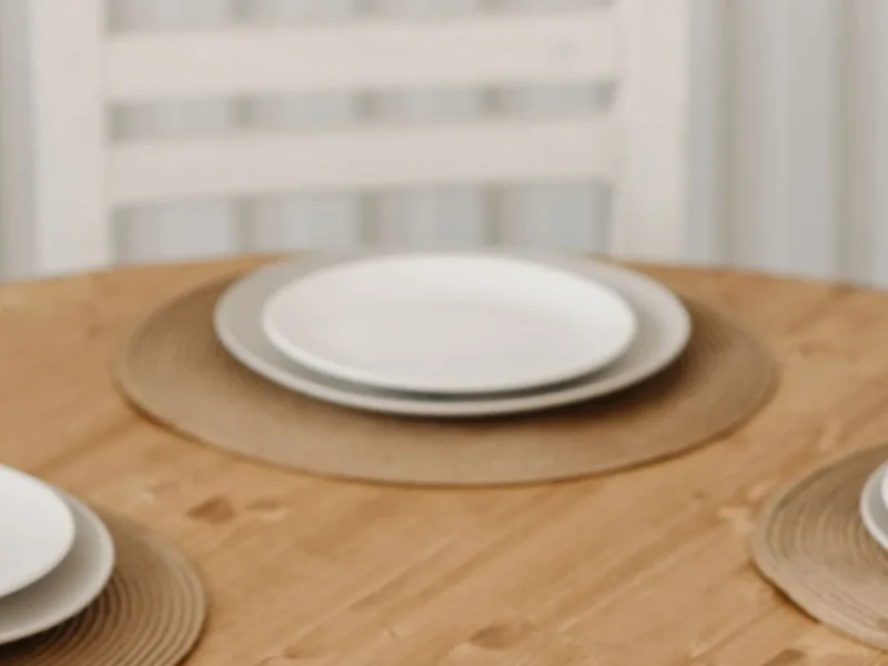 Plato blanco sobre un individual en una mesa de madera
