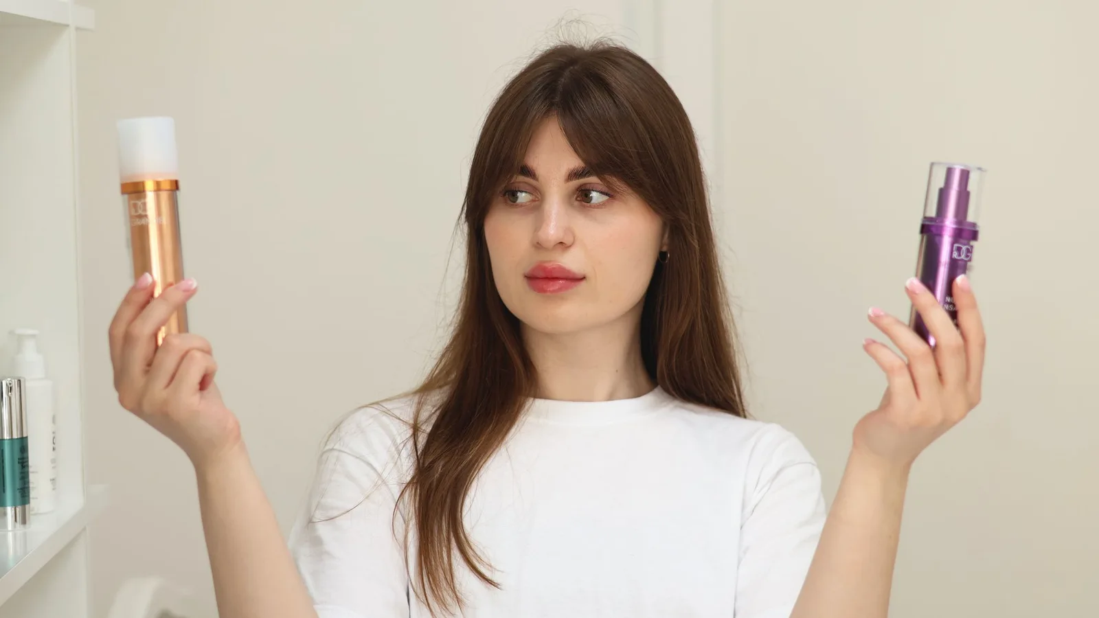 Mujer mirando dos productos cosméticos que sostiene por separado en las manos.