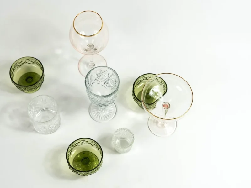 Vasos y copas transparentes y verdes de distintas formas vistos desde arriba